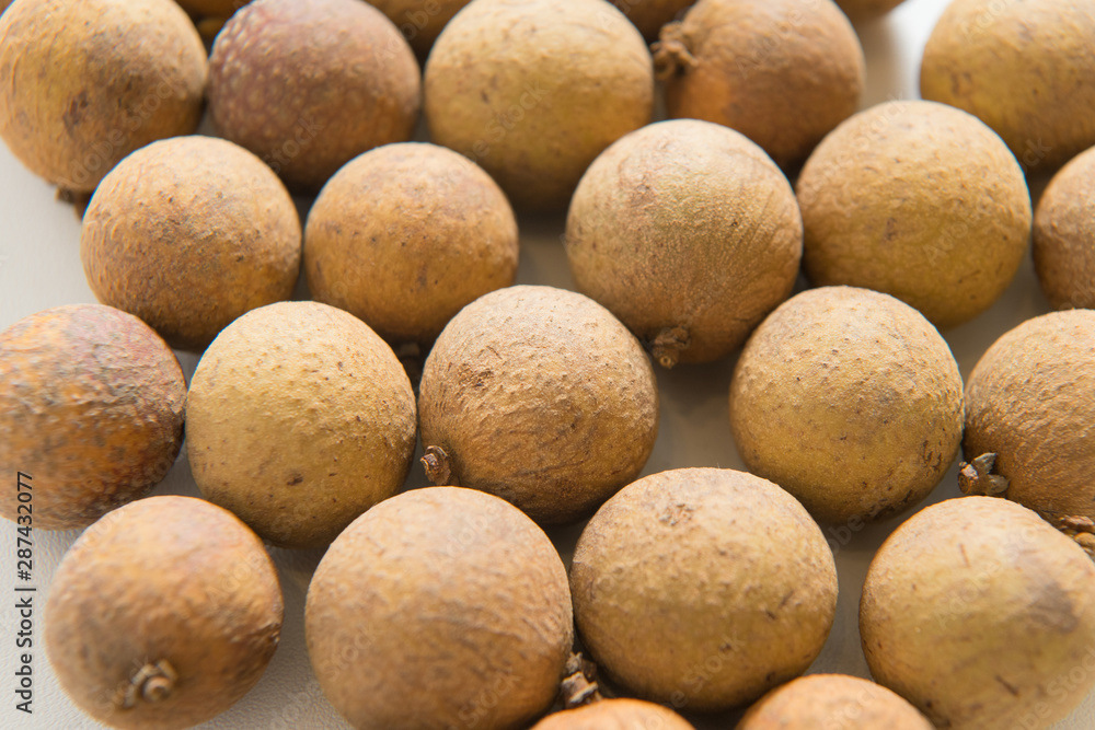 Longan arranged in a heart shape on a white background