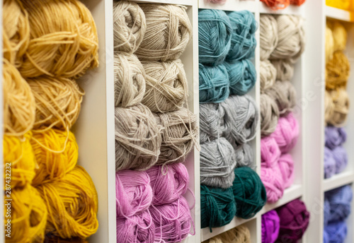 Knitting needles, colorful threads. Knitting pattern of colorful yarn wool on shopfront. Knitting background. Knitting yarn for handmade winter clothes. Colorful background with yarn ball. photo