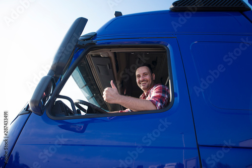 Photo Truck driver showing thumbs up through cabin window