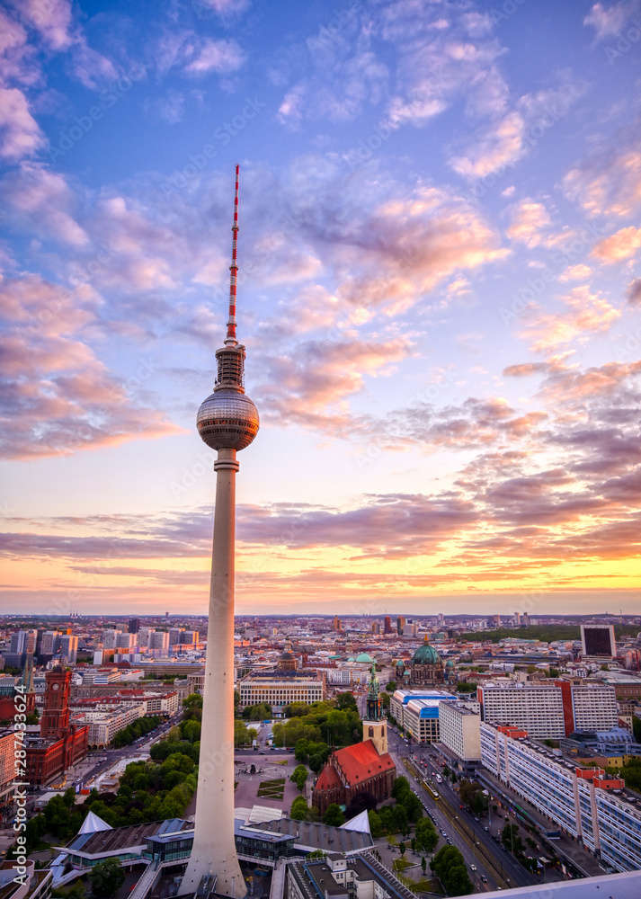 Obraz premium Widok na wieżę telewizyjną (Fernsehturm) nad miastem Berlin, Niemcy o zachodzie słońca.