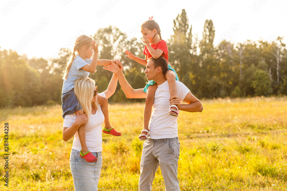 young familiy running through a yellow field young familiy running through a yellow field