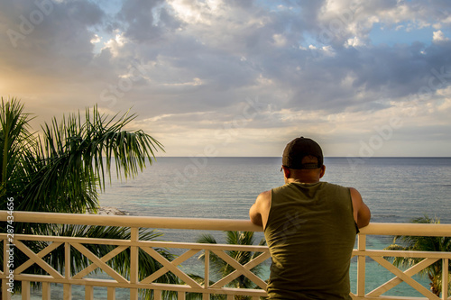 Man looking at ocean over balcony