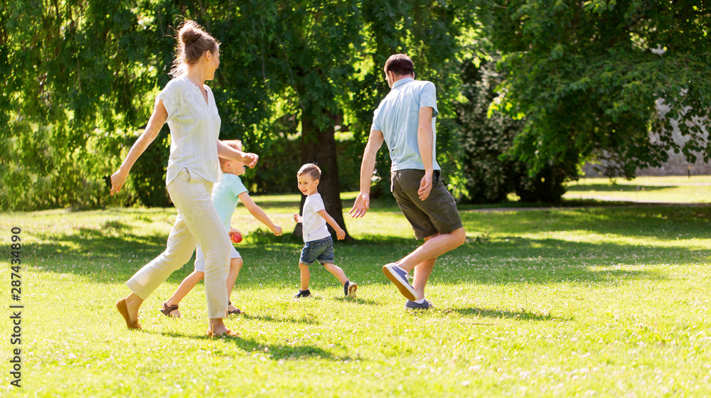 Obraz premium family, leisure and people concept - happy mother, father and two little sons having fun and playing at summer park