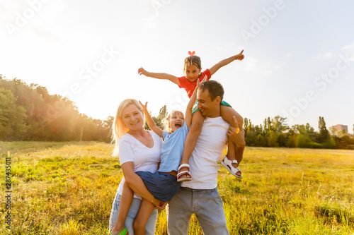 young familiy running through a yellow field photo