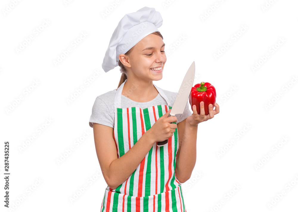 Portrait of beautiful young teen girl holding fresh red pepper and knife, isolated on white background. Smiling cute child cook in apron with healthy vegetables in hands. Organic natural food produce. Portrait of beautiful young teen girl holding fresh red pepper and knife, isolated on white background. Smiling cute child cook in apron with healthy vegetables in hands. Organic natural food produce.