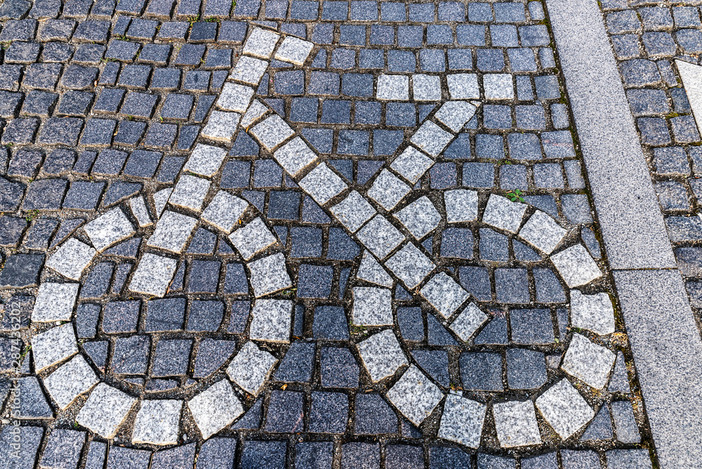 Bicycle road sign made of stone pavers on bike lane Bicycle road sign made of stone pavers on bike lane