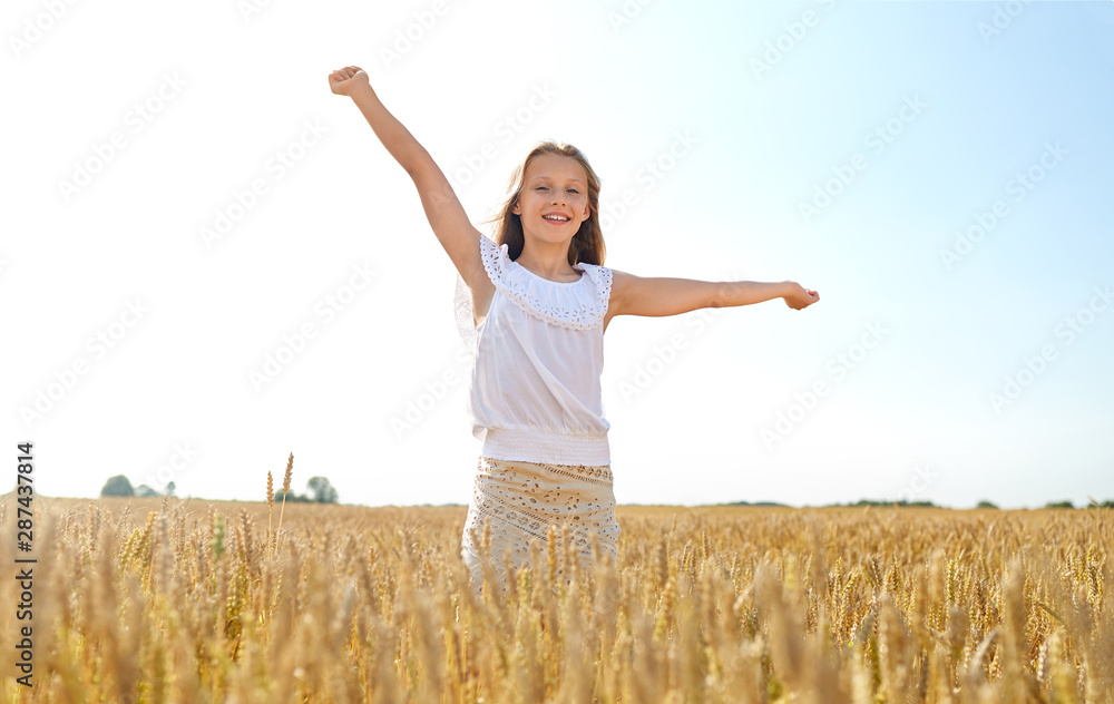 nature, harvest and freedom concept - happy young girl with hands outstretched on cereal field in summer nature, harvest and freedom concept - happy young girl with hands outstretched on cereal field in summer