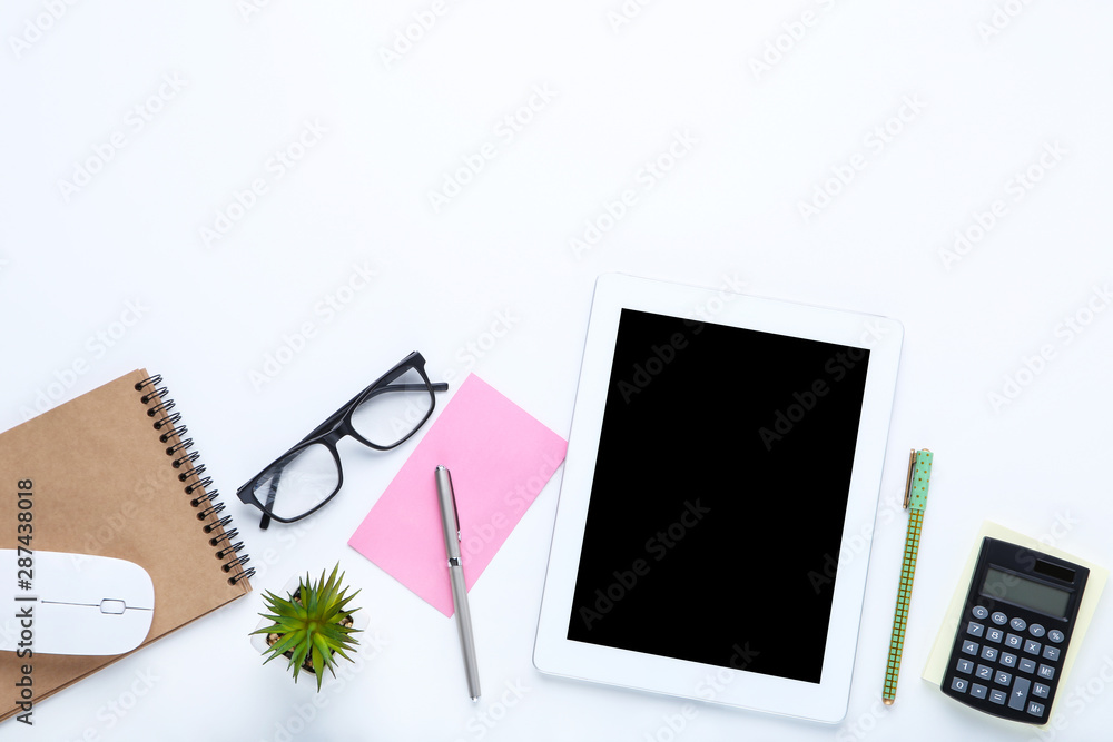 Tablet computer with office supplies on white background Tablet computer with office supplies on white background