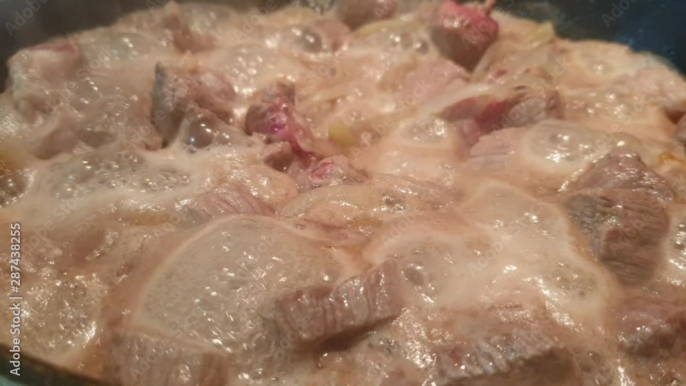 The housewife puts the chopped meat in a frying pan The housewife puts the chopped meat in a frying pan