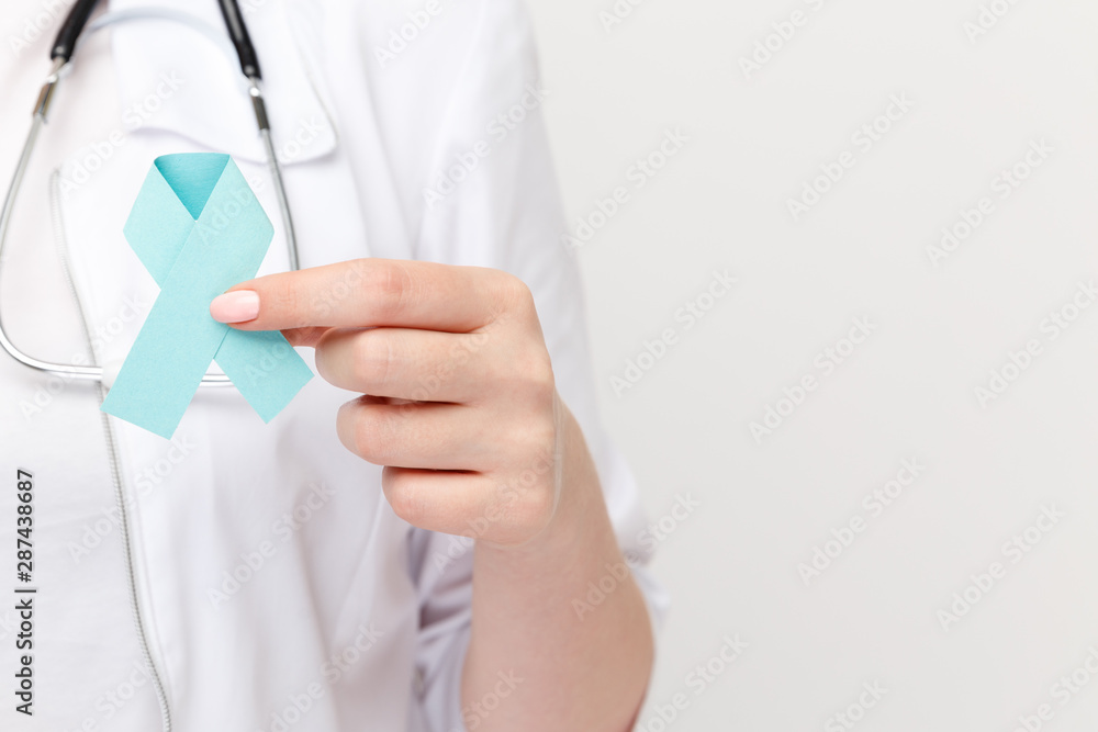 Female hand holding blue ribbon isolated Female hand holding blue ribbon isolated