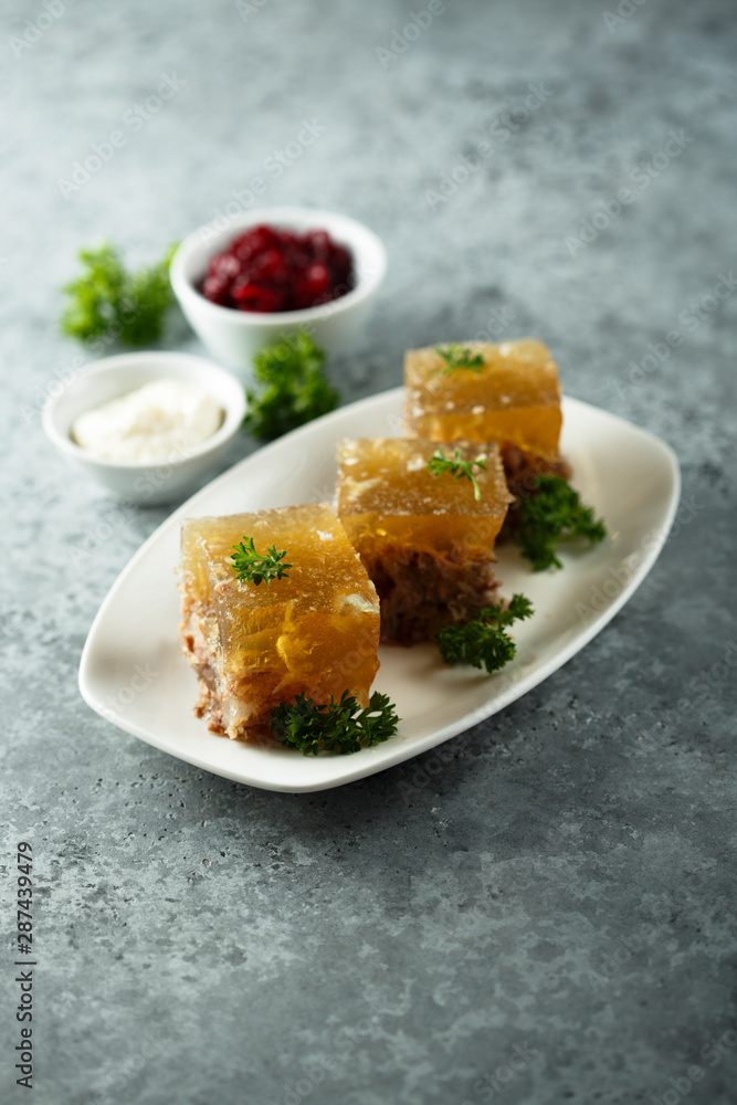 Festive meat jelly with sauces on white plate Festive meat jelly with sauces on white plate