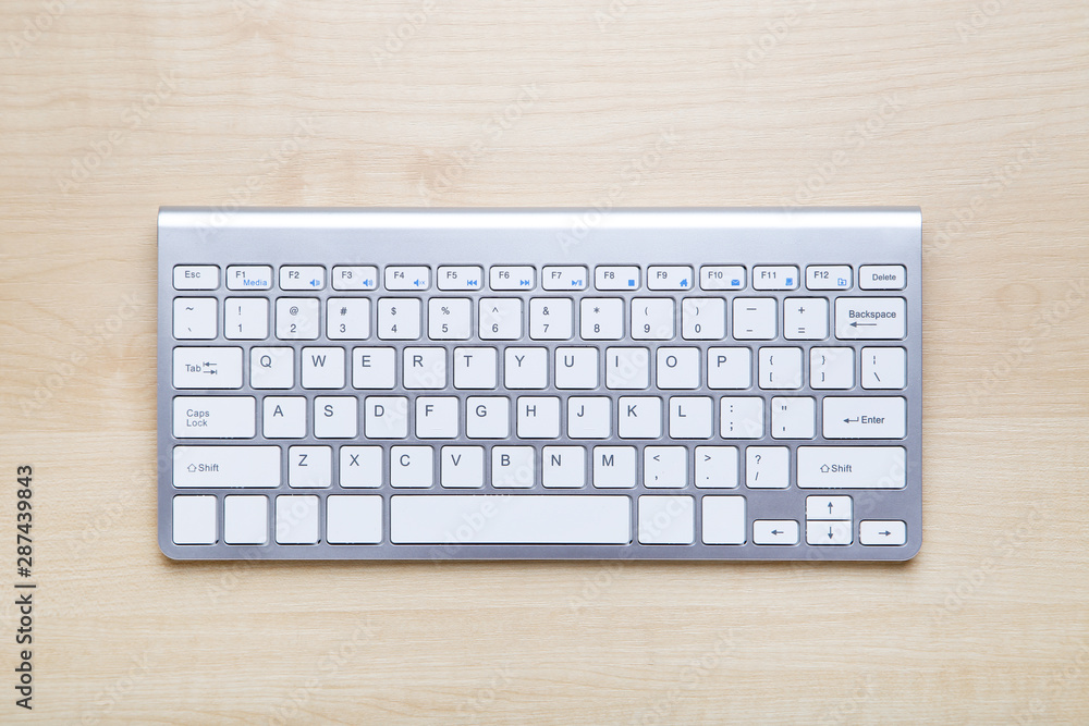 Computer keyboard on brown wooden table