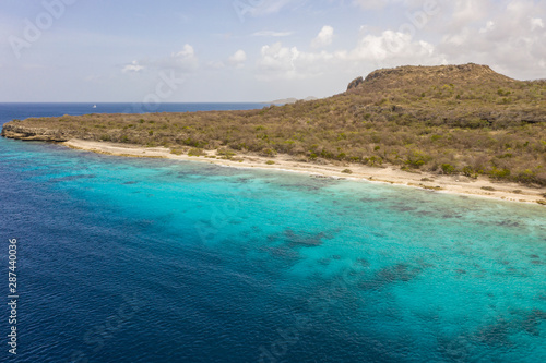 Aerial view of coast of Curaçao in the Caribbean Sea with turquoise water, cliff, beach and beautiful coral reef around Playa Largu