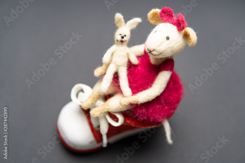 Close-up of felted wool toy. Hobbies, handmade, craft, leisure, learning, mouse, creativity, design concept, hare. Beautiful figure with a sneaker © Ilya