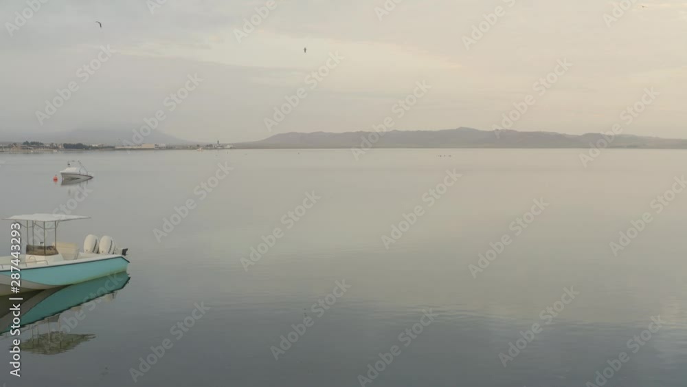 View flying near boats in calm waters in the morning. Sunrise at Paracas Coast, Peru