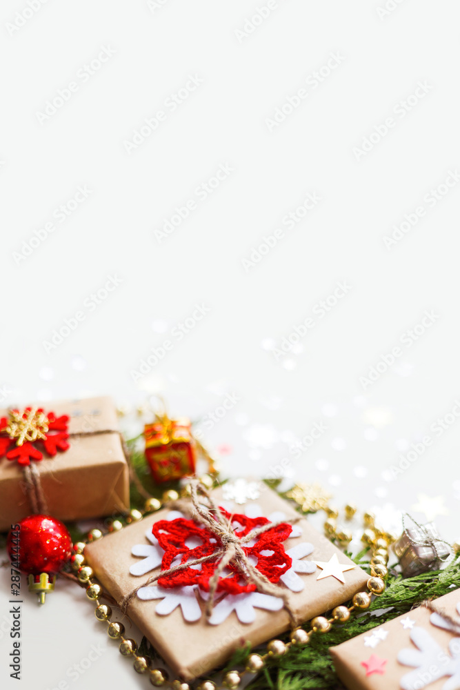 Christmas and New Year background with thuja branch, decorations and presents wrapped in craft paper with snowflakes. Copy space.