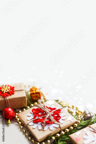 Christmas and New Year background with thuja branch  decorations and presents wrapped in craft paper with snowflakes. Copy space.