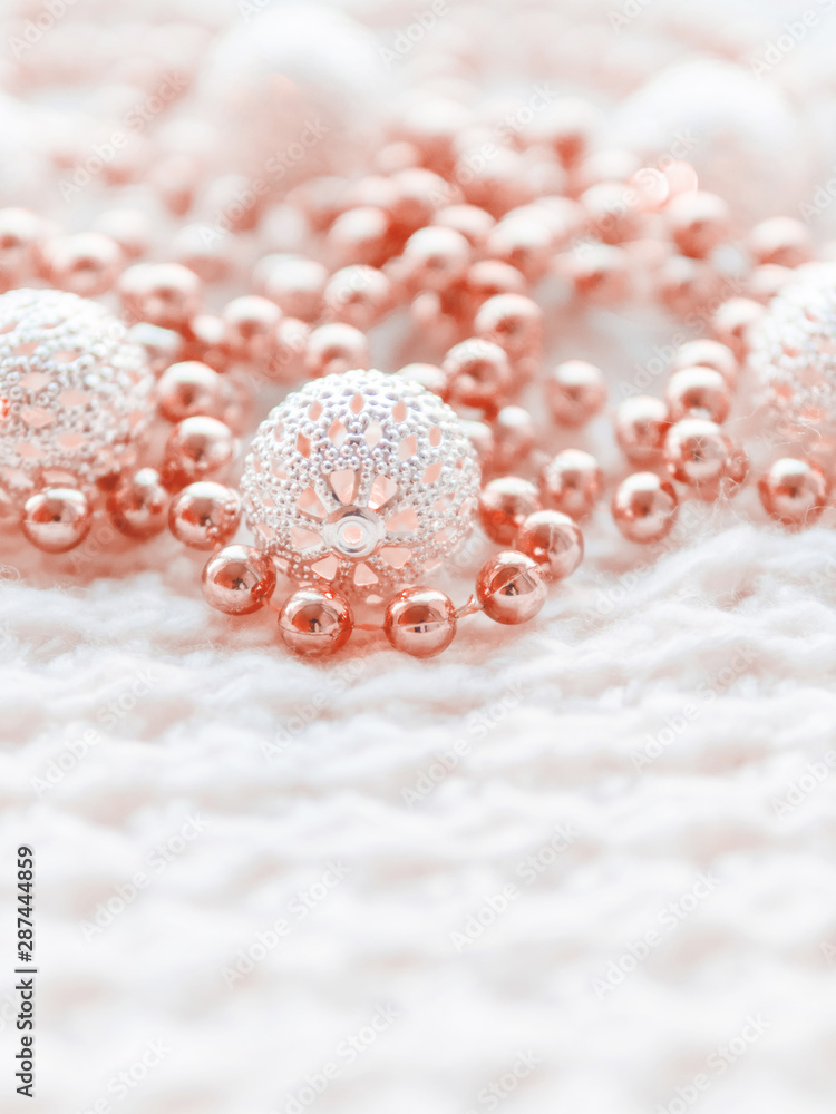 Obraz premium Christmas and New Year decorations on white knitted background. Metal light bulbs with delicate pattern, light red beads.