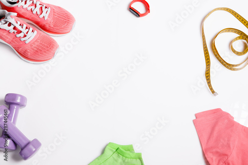 Fittnes sport composition with pink sneakers, t-shirt, dumbbells on white background. photo