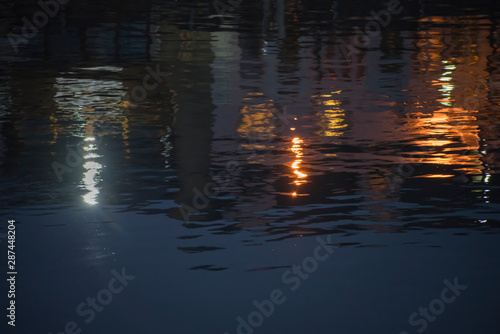 Evening lights reflected in the harbour water with ripples creating a pleasing pattern.