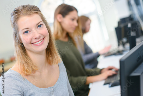 smiling young businesswoman using computer in office