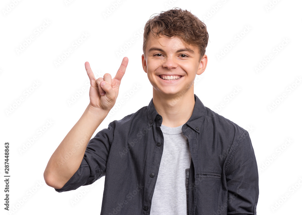 Portrait of teen boy making Rock Gesture, isolated on white background. Handsome caucasian young teenager showing horns up gesture. Happy cute child smiling and doing heavy metal rock sign. Portrait of teen boy making Rock Gesture, isolated on white background. Handsome caucasian young teenager showing horns up gesture. Happy cute child smiling and doing heavy metal rock sign.