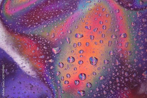 Drops of water on bright bold gradients of holographic neon colors. Concept art. Minimal background of surrealism