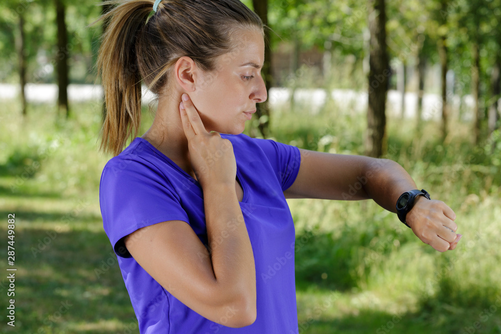 young female jogger looking at smartwatch young female jogger looking at smartwatch