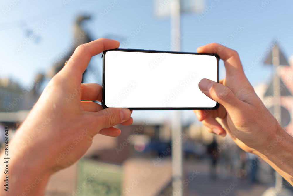 guy takes pictures on a smartphone. white screen mockup guy takes pictures on a smartphone. white screen mockup