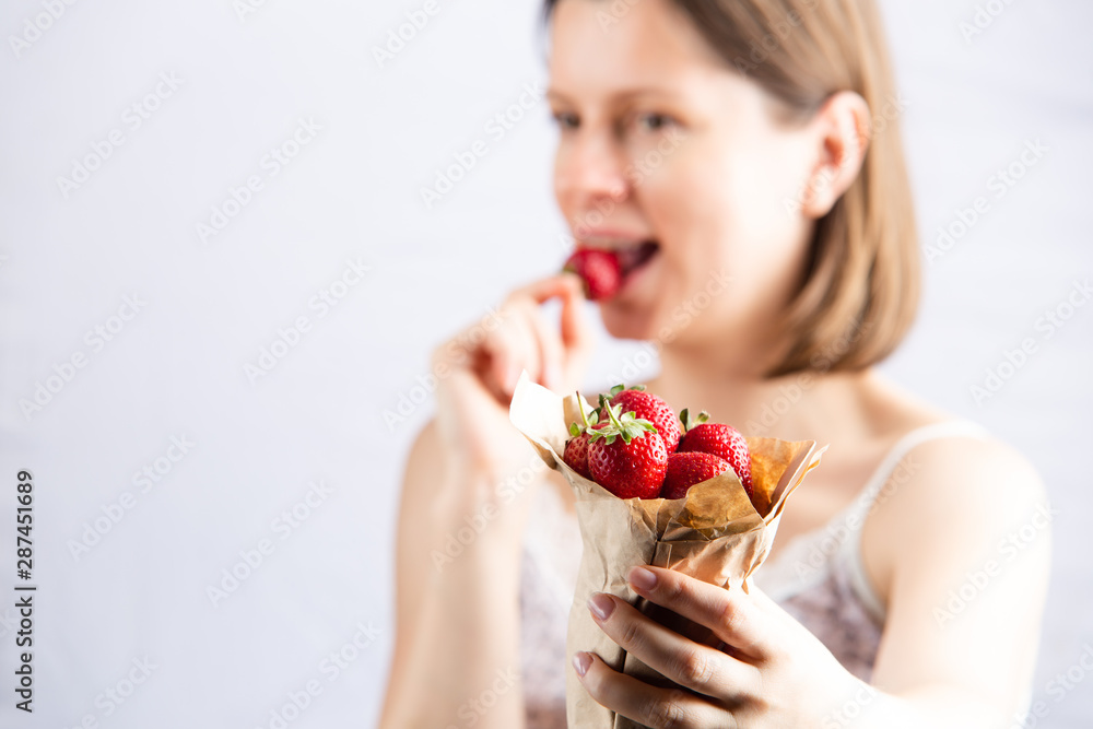 Young woman eating strawberry. Healthy snack for vegetarians. Young woman eating strawberry. Healthy snack for vegetarians.