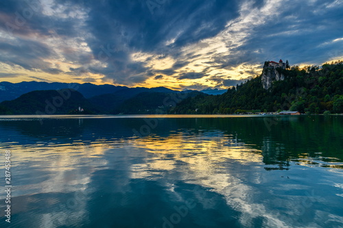 Evening (golden hour) landscape on Lake Bled with reflection and beautiful cloudy sky.