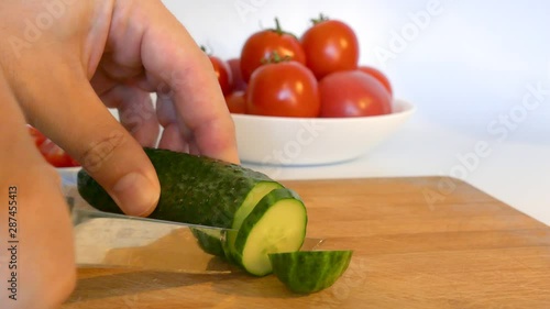 Cooking vegetables with a knife. Green fresh cucumber.