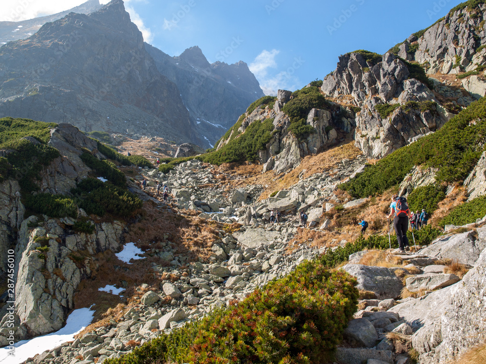 Vysoke Tatry, Slovakia - October 10, 2018: Hikers on trail at Great Cold Valley,  Vysoke Tatry (High Tatras), Slovakia. The Great Cold Valley is 7 km long valley, very attractive for tourists