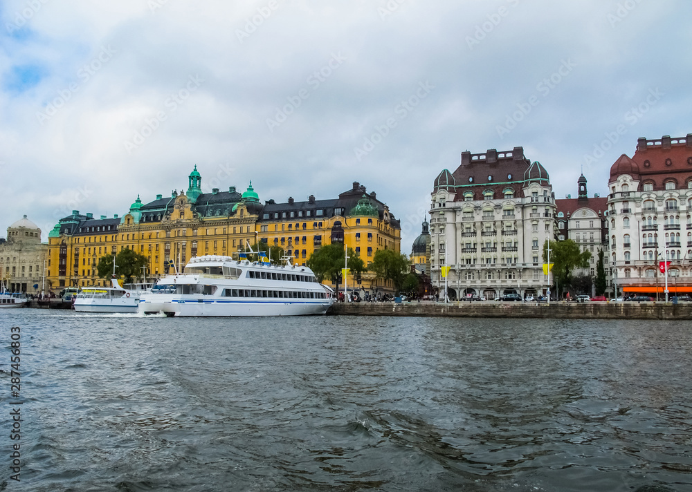 Panoramic view from the tourist excursion boat to the pier with boats and the beautiful buildings of Stromkayen in the center of Stockholm Sweden