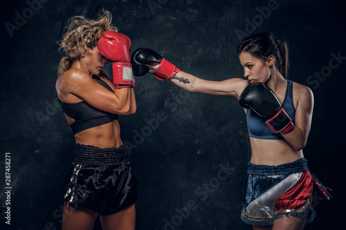 Process of fight between two female boxers, one of them got hit from another. © Fxquadro