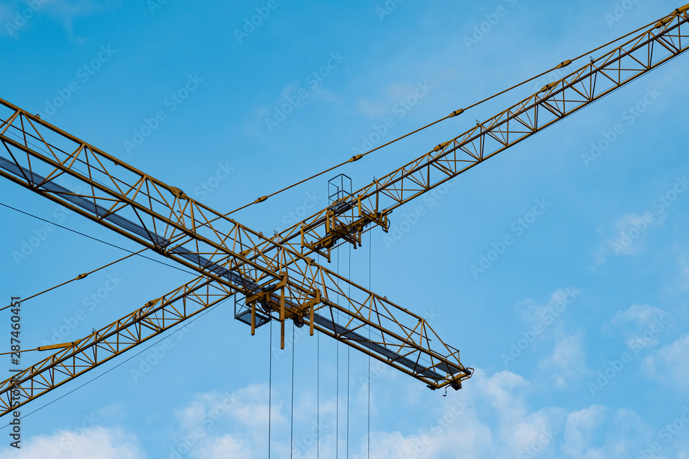 Tower Cranes Against Blue Sky Background.