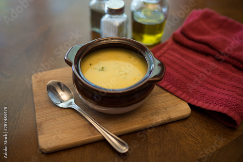 broccoli cheese soup served in a brown bowl 