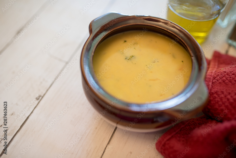 broccoli cheese soup served in a brown bowl broccoli cheese soup served in a brown bowl