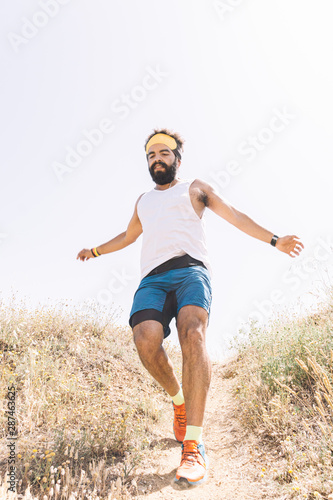 Man running up the mountain and jumping.