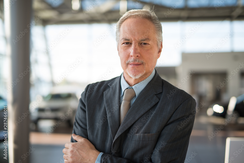 Car dealer salesman in his showroom Car dealer salesman in his showroom