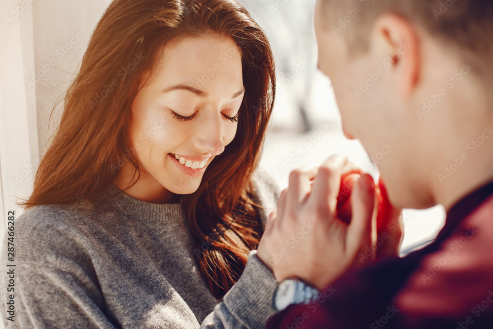 Cute couple have fun. Boy and girl in a winter park. Man in a red sweater. Brunette in a gray sweater Cute couple have fun. Boy and girl in a winter park. Man in a red sweater. Brunette in a gray sweater