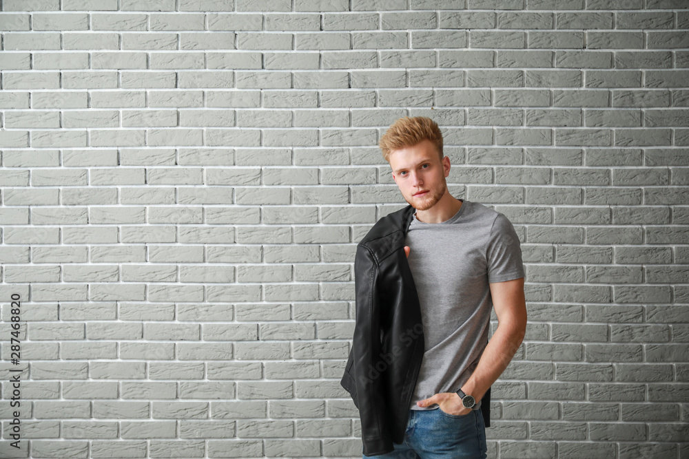 Man in stylish t-shirt near brick wall Man in stylish t-shirt near brick wall
