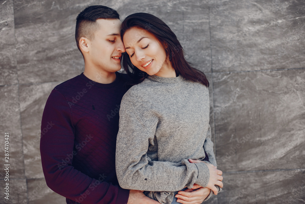 Cute couple have fun. Boy and girl in a winter park. Man in a red sweater. Brunette in a gray sweater Cute couple have fun. Boy and girl in a winter park. Man in a red sweater. Brunette in a gray sweater