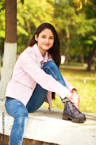 Portrait of a young girl in pink jacket on a background of autumn park photo