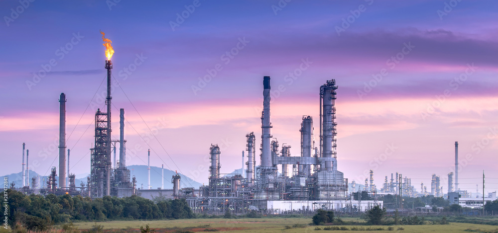 Oil and gas industrial refinery zone,Detail of equipment oil pipeline steel with valve from large oil storage tank at twilight.