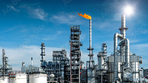 Close-up view Oil and gas industrial refinery zone,Detail of equipment oil pipeline steel with valve from large oil storage tank at cloudy sky. -image