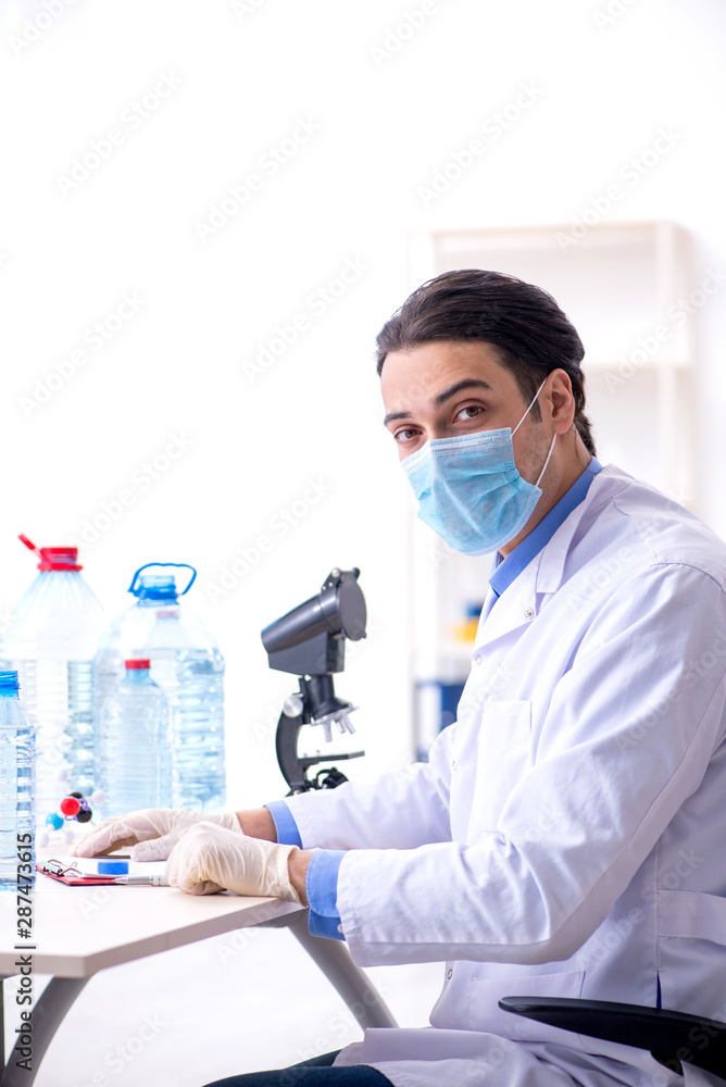 Young male chemist experimenting in lab Young male chemist experimenting in lab