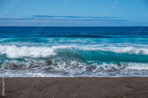 Foamy Atlantic ocean on black sand Beach of Santa Barbara, Sao Miguel Island, Azores, Portugal