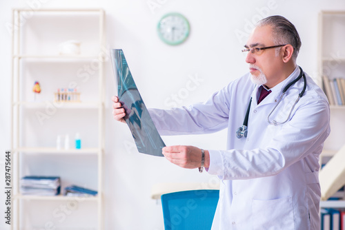 Old male doctor working in the clinic