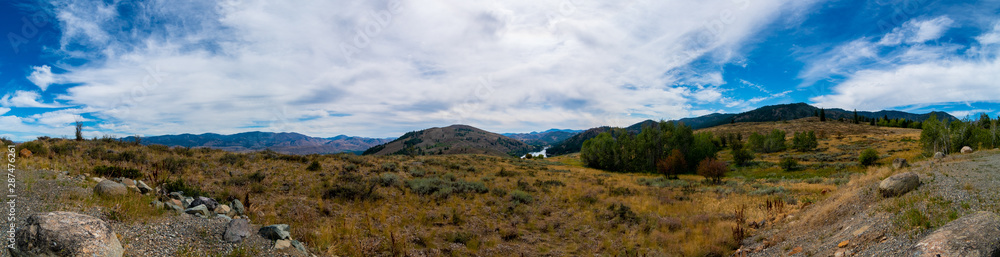 Panoramic Landscape of the Cascade Mountain Range with the Okanogan-Wenatchee National Forest, a Lake, Swirling Clouds and a Blue Sky in August Summertime